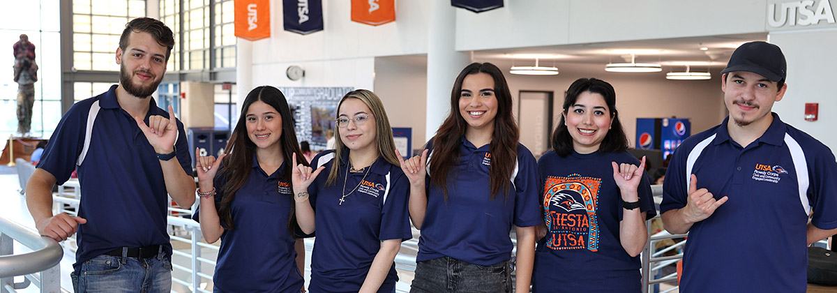 Group of students using the birds up sign in the student union